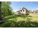Spacious backyard with manicured lawn, mature trees, and view of the home's exterior at 3053 Lawson Dr, Marietta, GA 30064