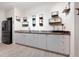 Basement bar area features white cabinets, stainless steel fridge, modern glassware, and a gray countertop at 3053 Lawson Dr, Marietta, GA 30064