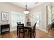 Cozy dining room with hardwood floors, a square wood table, and natural light from plantation-shuttered windows at 3053 Lawson Dr, Marietta, GA 30064