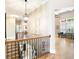 Upstairs hallway showcases iron railings, hardwood floors, decorative art, and elegant lighting at 3053 Lawson Dr, Marietta, GA 30064