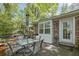 Outdoor patio with dining set, brick exterior, and wooded surroundings at 3139 Mary Dr, Marietta, GA 30066