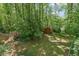 Backyard view of the red storage shed nestled among the trees, providing ample space for tools and equipment at 3139 Mary Dr, Marietta, GA 30066