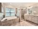 Bathroom view with a tiled shower, bathtub, and double vanity with granite countertop at 3699 School Street, Chamblee, GA 30341