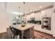 Modern kitchen with white cabinets, stainless steel appliances, and a granite-topped island with bar seating at 3699 School Street, Chamblee, GA 30341