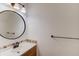 Bathroom with white counter top, dark hardware, and large round mirror at 3987 Ivory Gables Pl, Buford, GA 30519