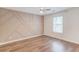 Bedroom with hardwood floors, a modern accent wall and a bright window at 3987 Ivory Gables Pl, Buford, GA 30519