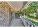 Covered front porch featuring a white railing with brick columns providing a view of the landscaped yard at 3987 Ivory Gables Pl, Buford, GA 30519