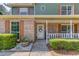 Inviting covered front porch with brick facade, white railing, and decorative wreath on the front door at 3987 Ivory Gables Pl, Buford, GA 30519