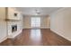 Bright living room featuring hardwood floors, a stone fireplace, and ample natural light creating an inviting atmosphere at 3987 Ivory Gables Pl, Buford, GA 30519