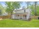 Backyard view showcasing the exterior of the house, covered patio, and lawn at 6891 Hickory Log Rd, Austell, GA 30168