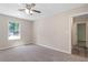 Bright bedroom features a ceiling fan, plush carpet, and a window offering natural light at 6891 Hickory Log Rd, Austell, GA 30168