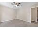 Carpeted bedroom with a ceiling fan, neutral walls, and a doorway to the hallway at 6891 Hickory Log Rd, Austell, GA 30168