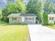 Charming home featuring a well-maintained lawn, gray painted brick foundation and concrete driveway at 1677 Wayland Ne Cir, Brookhaven, GA 30319