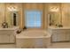Relaxing bathroom featuring double sinks, separate vanities, and a large soaking tub for comfort at 2611 Fireside Sw Trl, Conyers, GA 30094