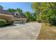 Wide driveway leading to a brick home with a spacious garage and lush landscaping at 2611 Fireside Sw Trl, Conyers, GA 30094