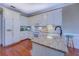 Bright kitchen with white cabinets, granite counters, stainless appliances, and hardwood flooring at 2611 Fireside Sw Trl, Conyers, GA 30094