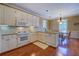 Traditional kitchen featuring white cabinetry, granite counters, and a dining area with natural light at 2611 Fireside Sw Trl, Conyers, GA 30094