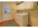 Functional laundry room with white cabinets and a matching washer and dryer set, offering convenience at 2611 Fireside Sw Trl, Conyers, GA 30094