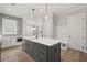 Kitchen island with gray cabinets and white countertops; includes a built-in dishwasher at 3003 Clayton St, Woodstock, GA 30188