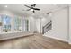 Sun-drenched living room showcasing hardwood floors, large windows, and staircase at 3003 Clayton St, Woodstock, GA 30188