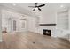 Bright, open-concept living room features hardwood floors, a fireplace, and built-in shelving at 3003 Clayton St, Woodstock, GA 30188