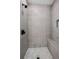 Luxurious shower featuring gray tile, a built-in bench, and a rainfall shower head at 3003 Clayton St, Woodstock, GA 30188