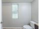 Bright half-bath with neutral walls, a window, a toilet and wooden-style floor at 3897 Mcgill Dr, Decatur, GA 30034
