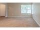 Spacious living room featuring a large window, plush carpeting, and ample space for furniture arrangement at 3897 Mcgill Dr, Decatur, GA 30034
