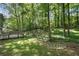 Large, lush backyard with mature trees, rock features, a spacious lawn, and a wooden deck for outdoor entertaining at 4628 Mountain Creek Ne Dr, Roswell, GA 30075