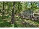 Two-story home with backyard featuring a wooden deck and patio, surrounded by mature trees for privacy and beauty at 4628 Mountain Creek Ne Dr, Roswell, GA 30075