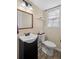 Updated bathroom featuring a dark vanity, toilet, a wood trimmed mirror, and a view of the window with closed blinds at 4628 Mountain Creek Ne Dr, Roswell, GA 30075