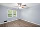 The bedroom has wood floors, neutral paint and a double-hung window at 4628 Mountain Creek Ne Dr, Roswell, GA 30075