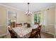 Cozy dining room featuring hardwood floors, a chandelier, and large windows for natural light at 4628 Mountain Creek Ne Dr, Roswell, GA 30075