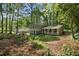 View of the two-story house in its large lot with mature trees surrounding the residence at 4628 Mountain Creek Ne Dr, Roswell, GA 30075