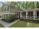 Charming two-story home featuring a brick facade, green siding, and a welcoming front porch at 4628 Mountain Creek Ne Dr, Roswell, GA 30075