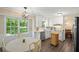 Eat-in kitchen with white cabinets, stainless steel dishwasher, natural light, and a view of the wooded area outside at 4628 Mountain Creek Ne Dr, Roswell, GA 30075