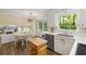 Bright kitchen featuring a dining area, stainless steel dishwasher, white cabinets, and a view of a green wooded area at 4628 Mountain Creek Ne Dr, Roswell, GA 30075