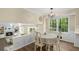 Cozy living room with hardwood floors, a brick fireplace, a modern light fixture, and four chairs at dining table at 4628 Mountain Creek Ne Dr, Roswell, GA 30075
