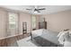 Neutral bedroom with hardwood floors, a dresser, a full size mirror, and windows with views to the neighborhood at 4628 Mountain Creek Ne Dr, Roswell, GA 30075