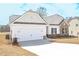 New home with a two-car garage, stone accents, and a well-maintained lawn on a sunny day at 494 Charleston Pl, Villa Rica, GA 30180