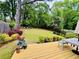 Lush backyard showcasing a well-maintained lawn, mature trees, and colorful landscaping seen from the deck at 67 Lannon Ne Ave, Atlanta, GA 30317