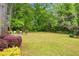 Large grassy backyard framed by mature trees and colorful landscaping at 67 Lannon Ne Ave, Atlanta, GA 30317