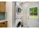 Convenient laundry room with stacked washer and dryer, cabinets, and exterior access at 67 Lannon Ne Ave, Atlanta, GA 30317