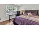 Bedroom featuring a bed with purple linens, a desk, and natural light from the window at 335 Pintail Ct, Suwanee, GA 30024