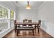 Bright dining room with hardwood floors, a modern light fixture, and large windows at 335 Pintail Ct, Suwanee, GA 30024
