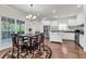 Bright kitchen features white cabinets, stainless steel appliances, island, and breakfast nook at 335 Pintail Ct, Suwanee, GA 30024