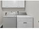 Laundry room with washer and dryer, complemented by white cabinets for storage at 335 Pintail Ct, Suwanee, GA 30024
