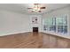 Spacious living room with hardwood floors, a fireplace, and large windows providing natural light at 335 Pintail Ct, Suwanee, GA 30024