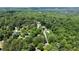 Scenic aerial view of community with lush trees and a glimpse of a lake in the background at 535 Silver Pine Trl, Roswell, GA 30076