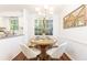 Bright dining area with wood floors, modern chandelier, and a large window looking out to the wooded property at 535 Silver Pine Trl, Roswell, GA 30076